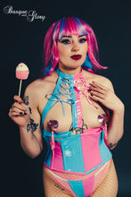 Load image into Gallery viewer, Person wearing a candy girl harness and corset, holding a lollipop with a dark background